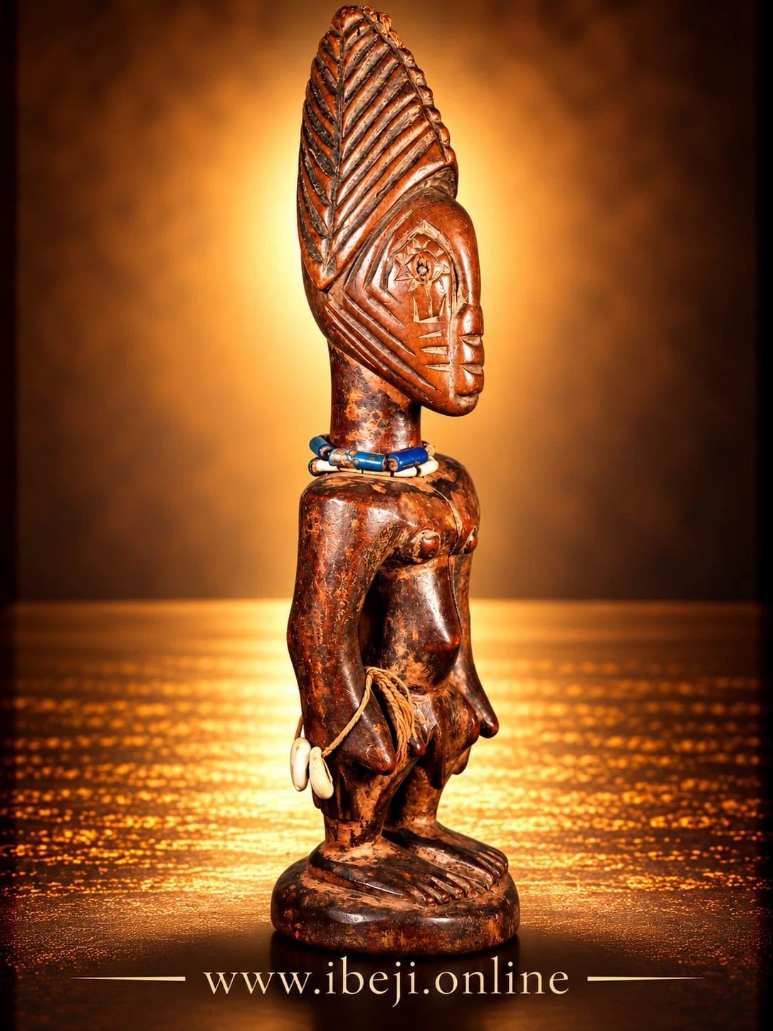 Perfil de una figura Ibeji con cofia elevada tallada y collares de cuentas