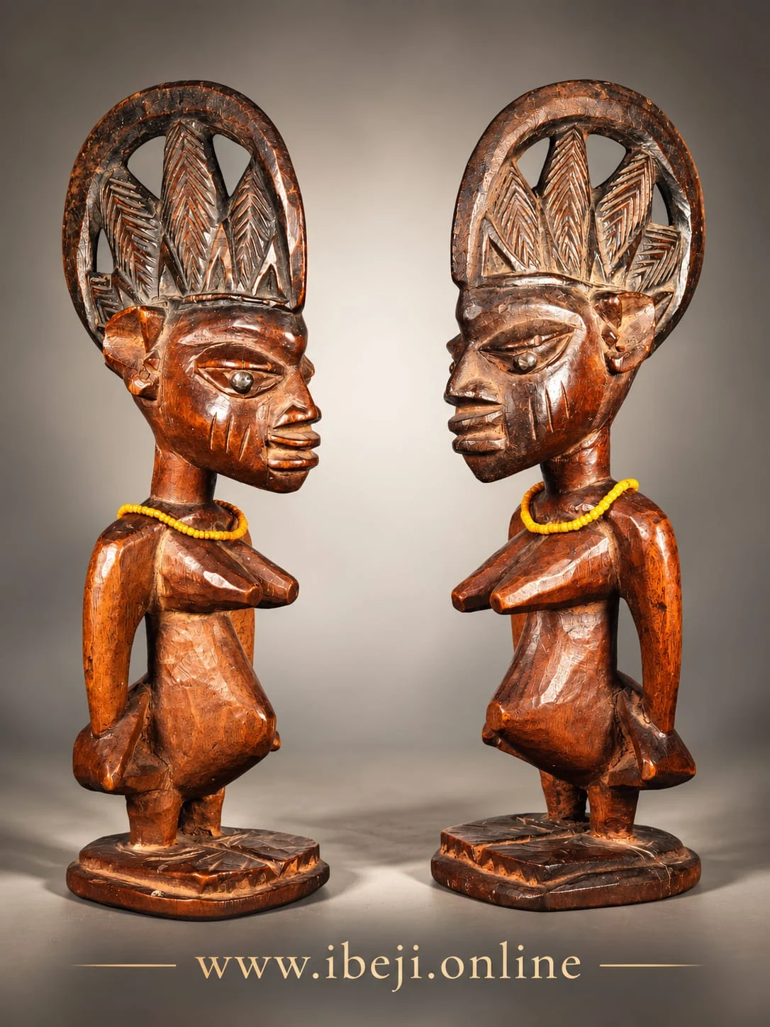 Dos figuras Ibeji yoruba de madera, con grandes cofias caladas y collares