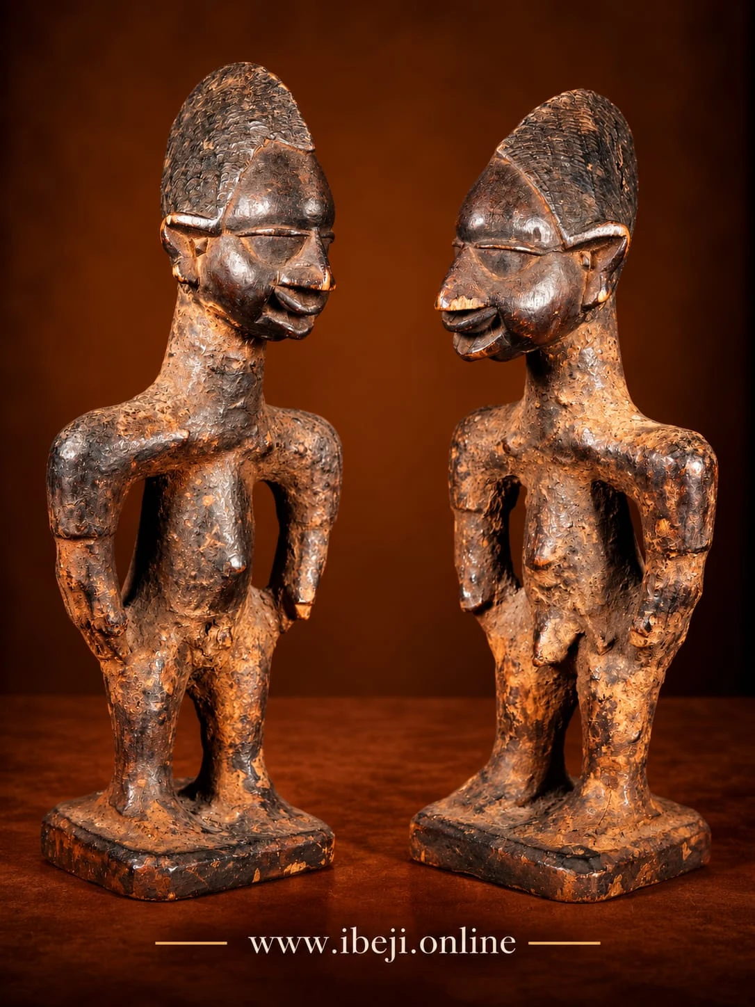Dos figuras Ibeji de madera con depósitos de materia y diferencias de desgaste en sus superficies